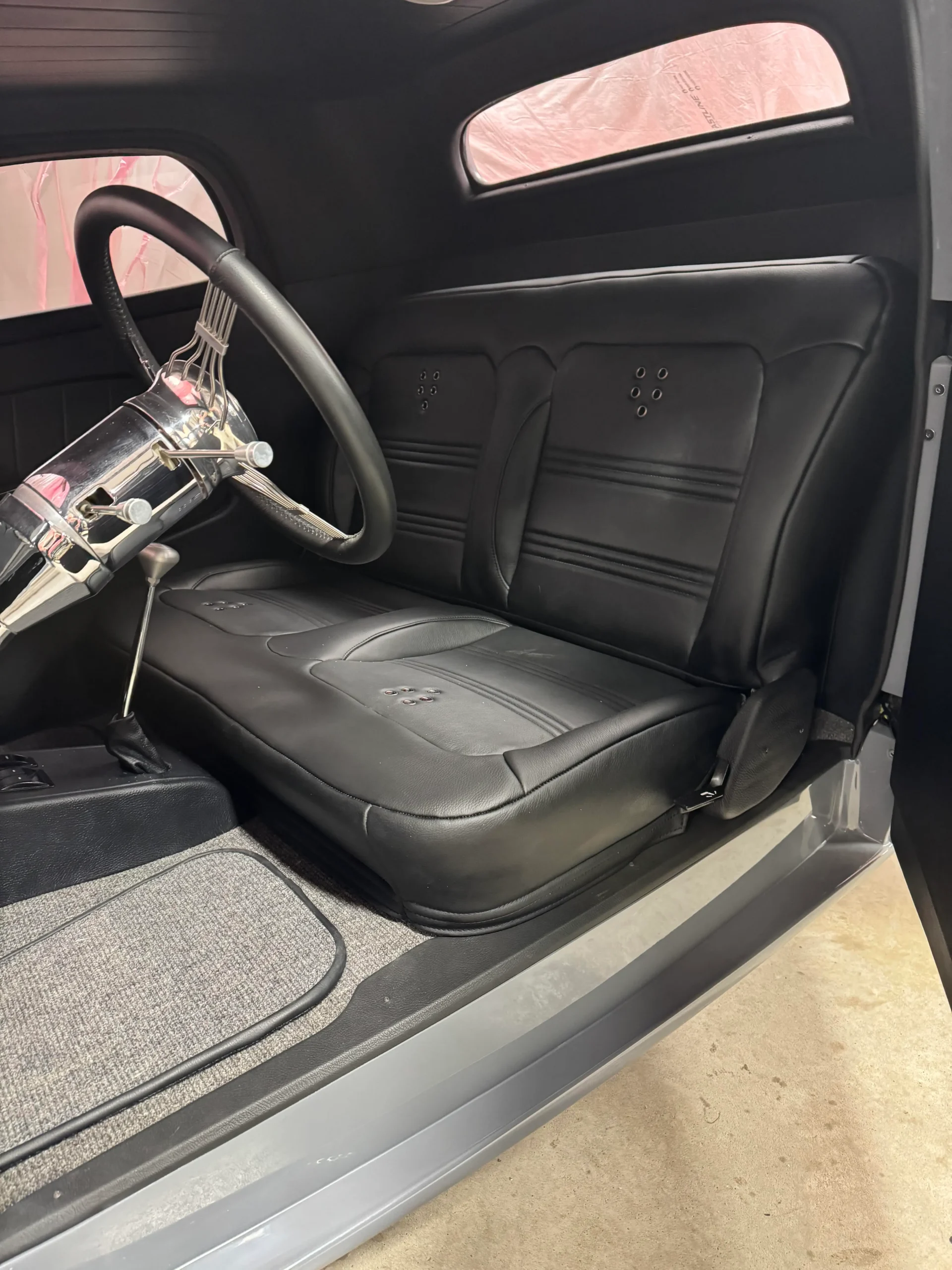 1933 Ford Coupe custom restoration with gray paint, polished wheels, wide rear tires, and classic hot rod styling