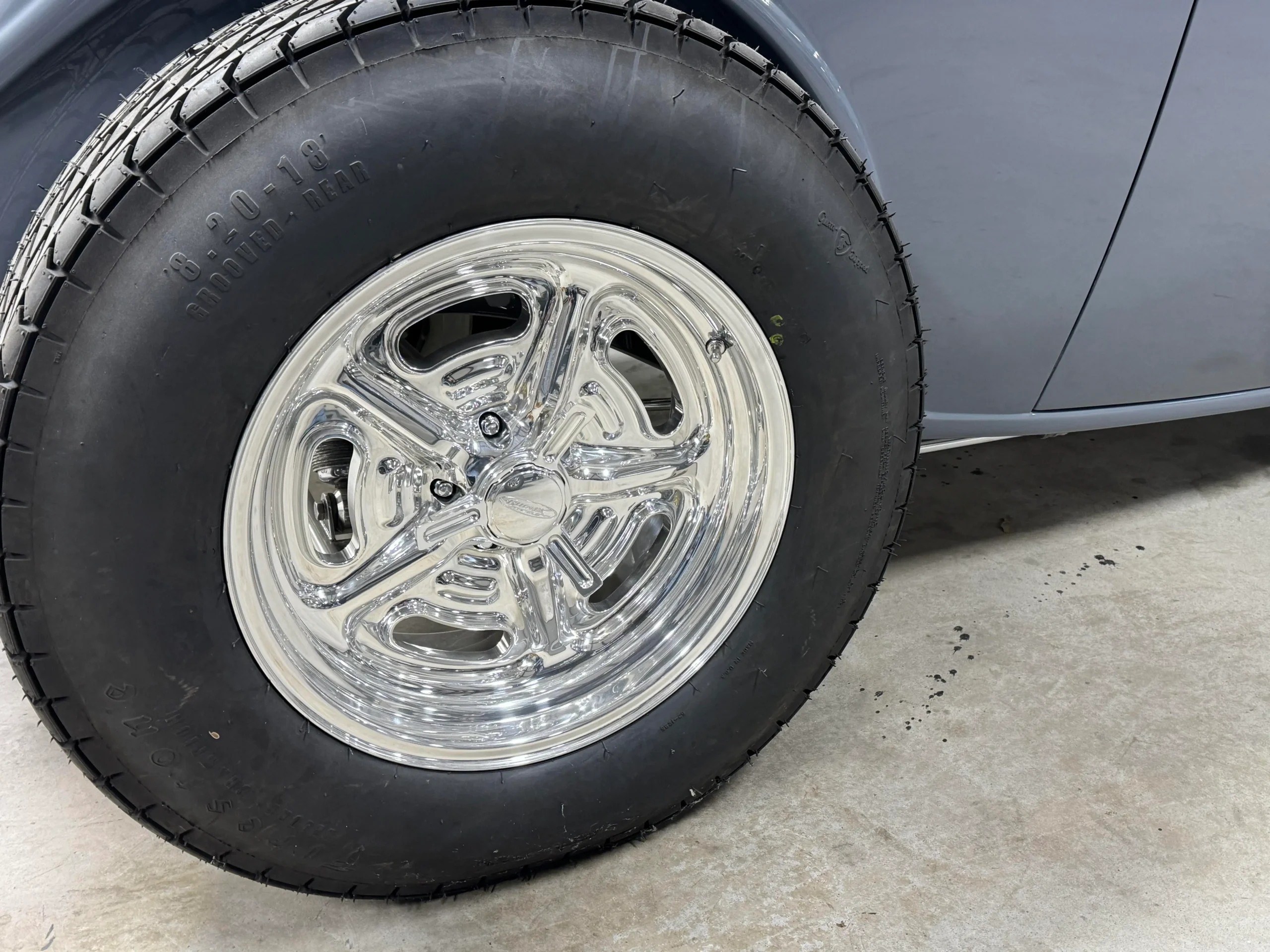 1933 Ford Coupe custom restoration with gray paint, polished wheels, wide rear tires, and classic hot rod styling