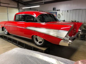 1957 Chevrolet 2-Door Hardtop restoration showing red paint, chrome rear trim, fins, and lowered stance