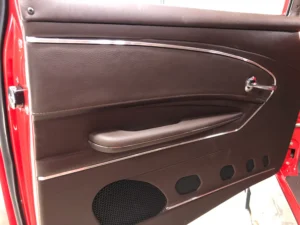 Custom door panel in a restored 1957 Chevrolet 2-Door Hardtop with clean trim and speaker detail