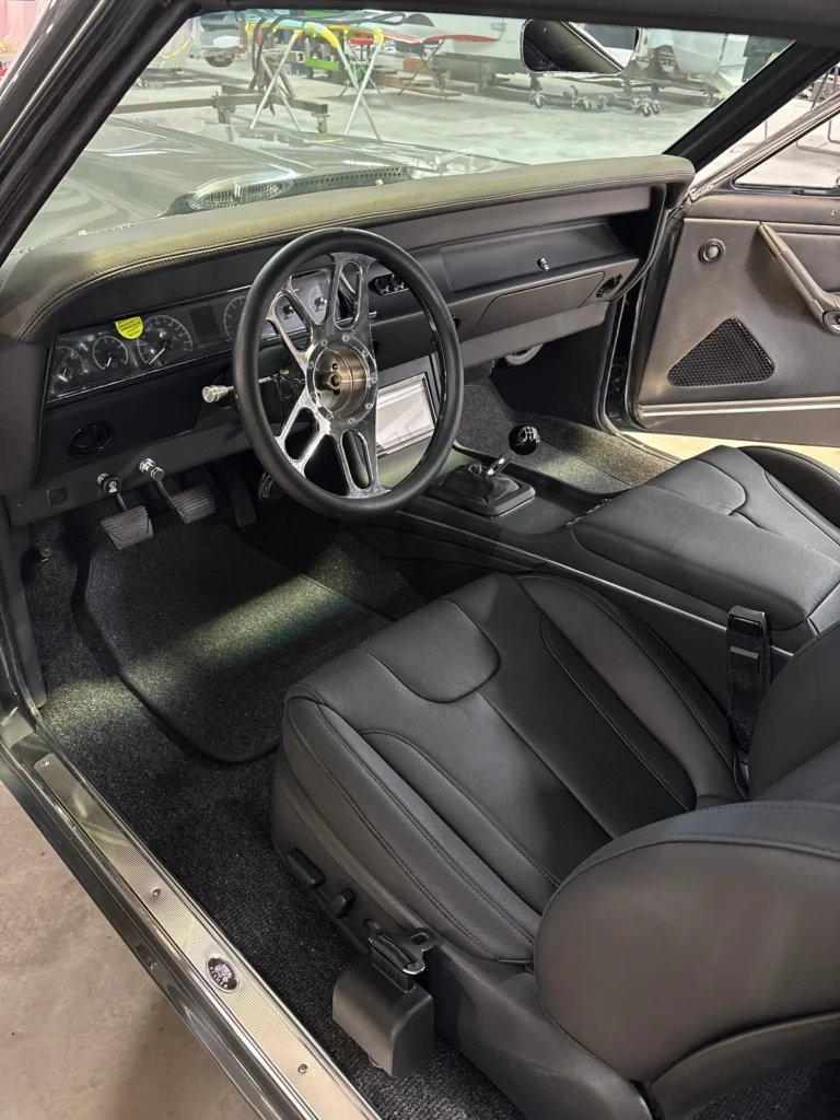 1967 Chevrolet Chevelle custom interior with black seats, custom console, steering wheel, and modern gauges