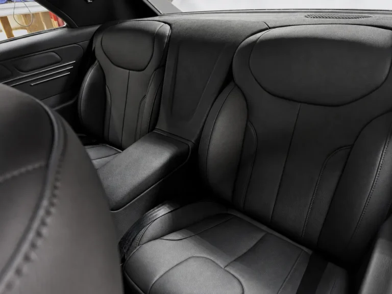 Custom black rear interior of a restored 1967 Chevrolet Chevelle with bucket seats and a center armrest.