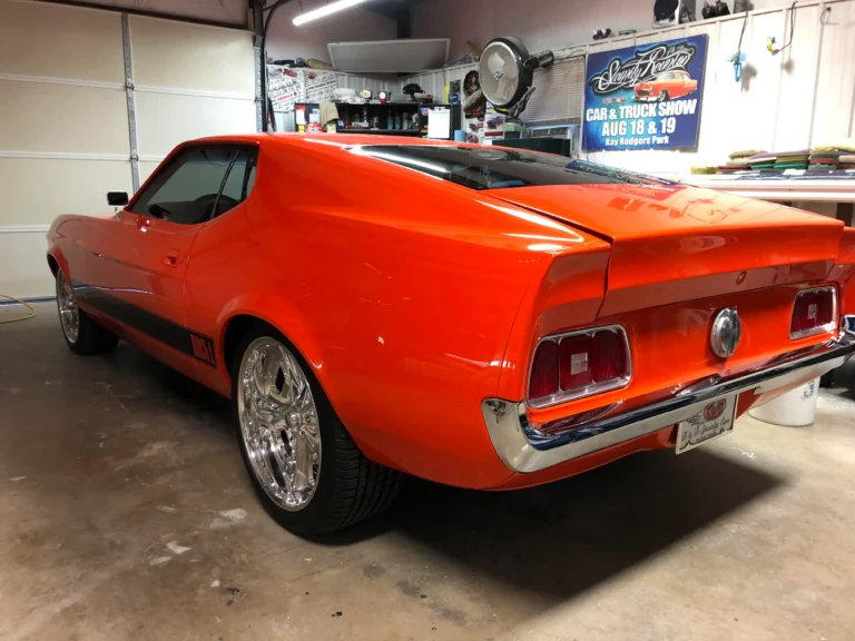 Custom built 1973 Ford Mustang Mach 1 with orange paint, black accents, chrome wheels, and fastback styling