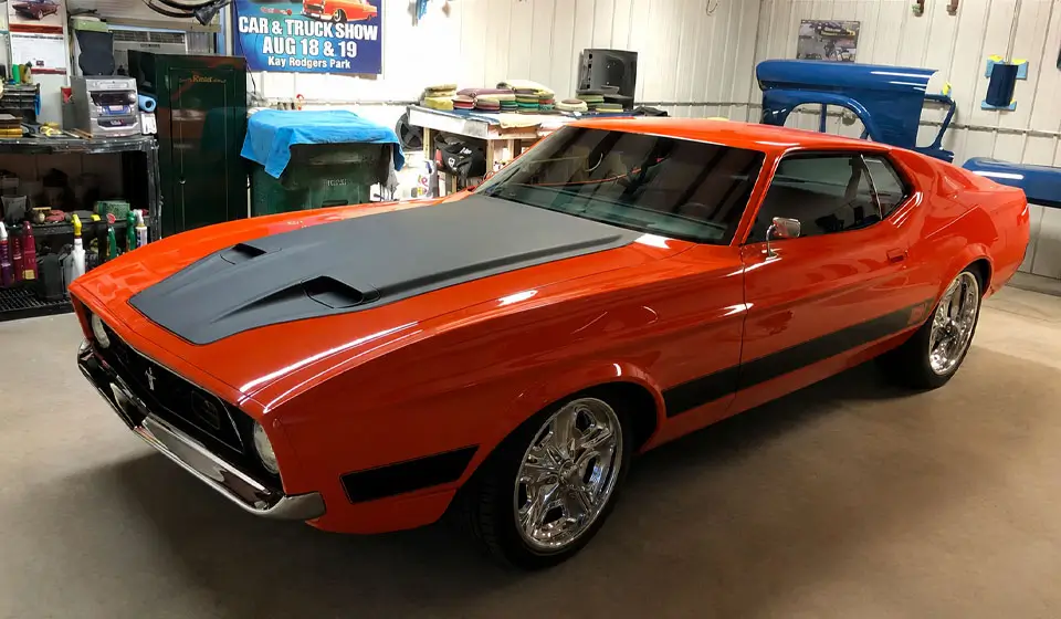 Custom built 1973 Ford Mustang Mach 1 full restoration with orange paint, black hood, and chrome wheels